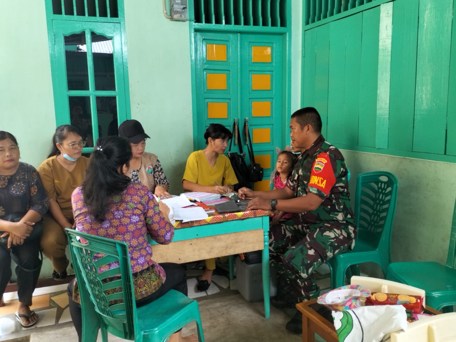 Foto : Babinsa Koramil 05/Kolang, Serda Rumondang Simanullang saat mendampingi pelaksanaan Posyandu di Kantor Kepala Desa Naga Timbul, Kecamatan Sitahuis, Kabupaten Tapanuli Tengah.