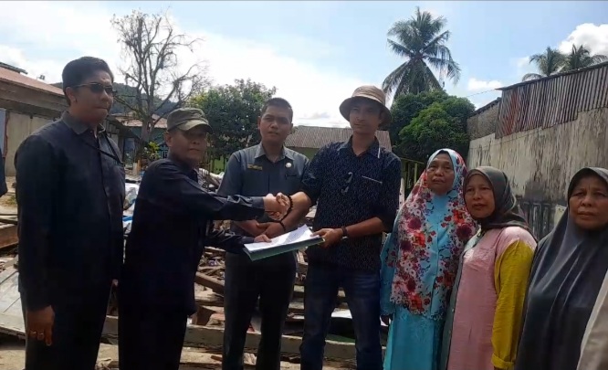 Foto : Penitera Pengadilan Negeri Sibolga, Joni Efendi, SH menyerahkan surat putusan Eksekusi kepada Tim Penasehat Hukum Hannum Silitonga dkk selaku pemohon usai pelaksanaan Eksekusi lahan