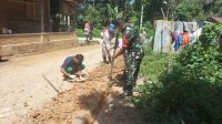 Keterangan Foto : Babinsa Koramil 05/Kolang, Serda Rondang Martua Manullang membantu warga menggali saluran pipa air bersih, di Desa Naga Timbul, Kabupaten Tapteng.