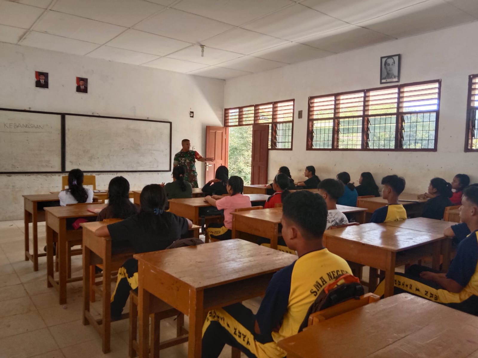 Keterangan Foto: Babinsa Koramil 05/Kolang, Serda Benni Sitompul menyampaikan materi Bela Negara dan Wasbang ke Pelajar SMA Negeri 1 Sitahuis di Desa Bonan Dolok, Kabupaten Tapteng.