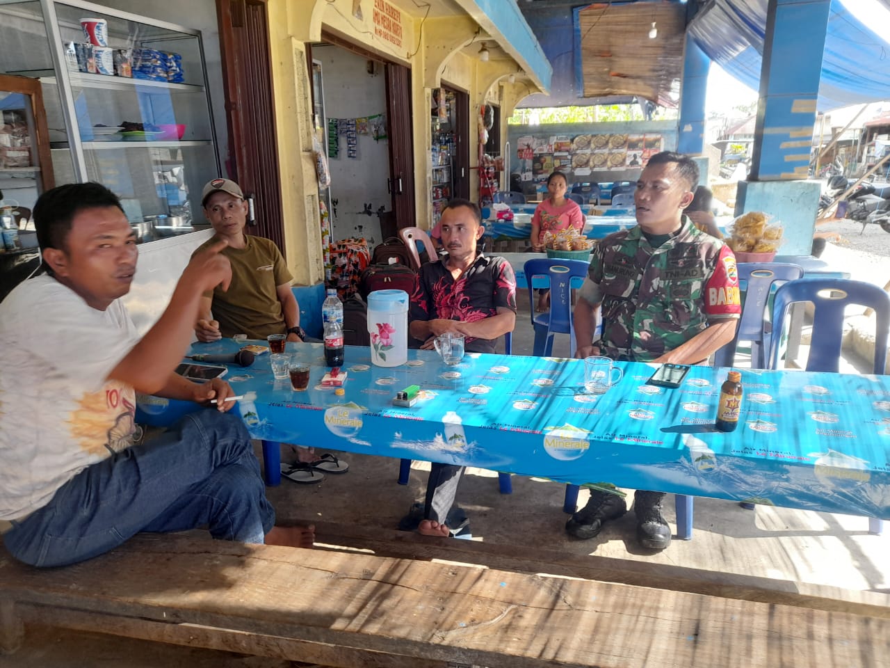 Keterangan Foto: Babinsa Koramil 06/Kota, Serda Rivai Manurung melaksanakan kegiatan Komsos dengan warga membahas perihal Kenakalan Remaja, di salah satu warung di Kelurahan Pancuran Dewa, Kota Sibolga.