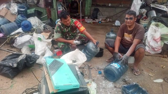 Keterangan Foto: Babinsa Koramil 06/Kota, Serda Ashadi Pasaribu saat berbaur dengan Pengepul barang rusak (botot), di salah satu gudang penampungan di Kelurahan Simaremare, Kota Sibolga.