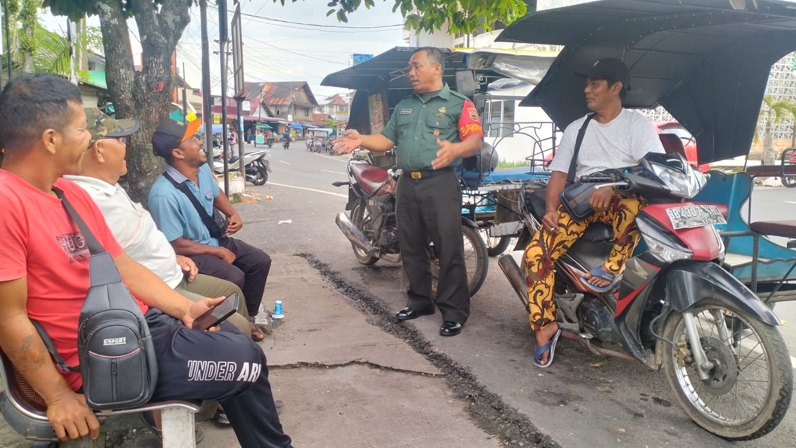 Keterangan Foto: Babinsa Koramil 06/Kota, Sertu Abdurrajab saat mengimbau para Abang Becak untuk tetap mematuhi Peraturan Lalu Lintas dan mematuhi Protokol Keselamatan.