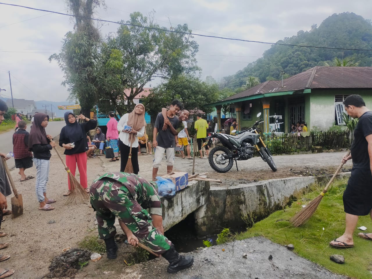 Foto : Serda Jusran Simanjuntak, Babinsa Koramil 03/Pandan saat membersihkan parit bersama warga di Kelurahan Aek Tolang Induk, Kecamatan Pandan