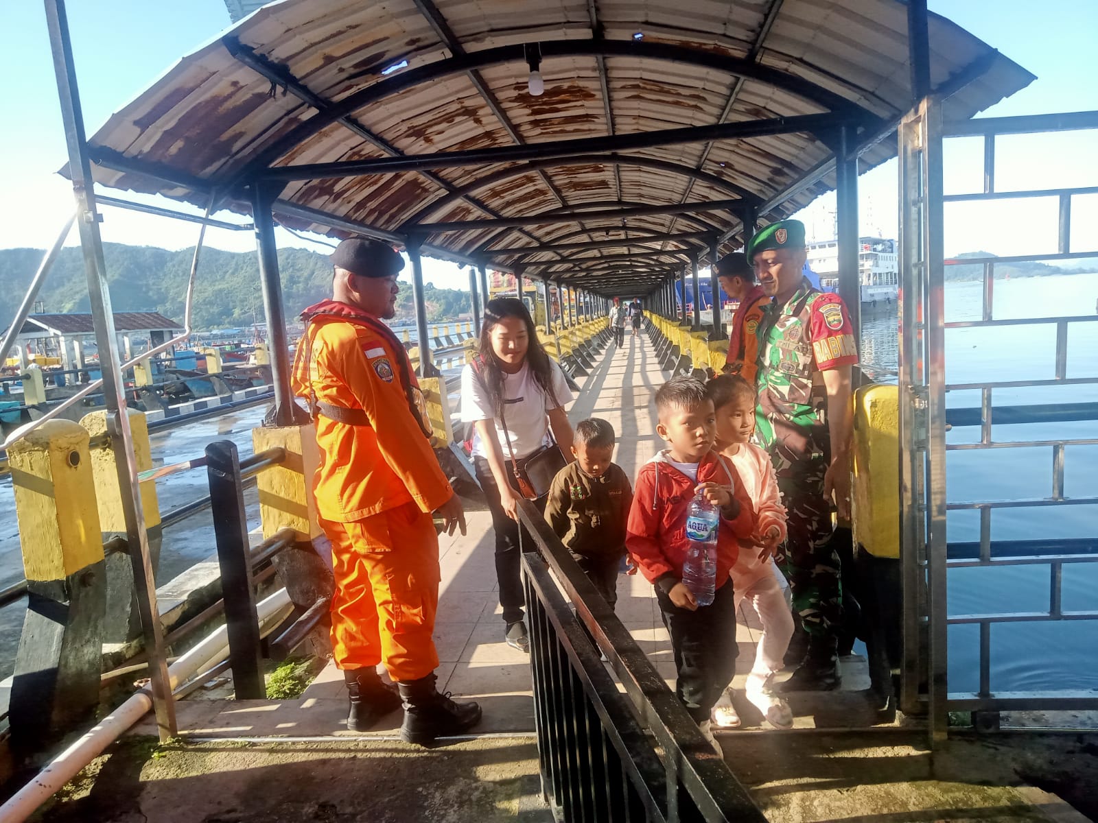 Keterangan Foto: Babinsa Koramil 06/Kota, Serda Alamsyah saat memantau dan mengingatkan penumpang kapal laut agar menjaga keselamatan, terutama mengawasi anak-anak di Pelabuhan ASDP, Kelurahan Aek Manis, Kota Sibolga.