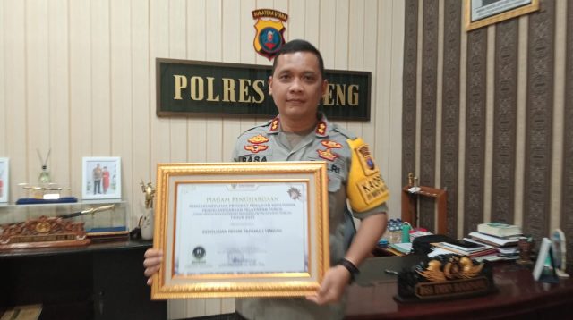 Foto : Kapolres Tapanuli Tengah, AKBP Basa Emden Banjarnahor saat menunjukkan Penghargaan dari Ombudsman RI