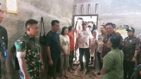 Keterangan Foto : Babinsa Koramil 06/Kota, Kopda Sapran Pasaribu bersama warga bergotong royong membersihkan material longsor di Kelurahan Aek Parombunan, Kota Sibolga.