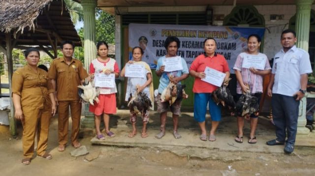 Foto : Kepada Desa Fajar, Kecamatan Sorkam, Besline Situmeang foto bersama dengan para keluarga Penerima Manfaat (KPM).