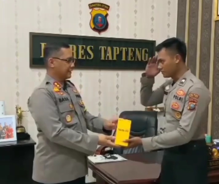Foto : Kapolres Tapanuli Tengah, AKBP Basa Emden Banjarnahor, SIK menyerahkan satu unit Handphone dari apresiasi Kadiv Propam Mabes Polri kepada, Irjen Pol Abdul Karim, SIK, MSI kepada Brigadir Rizky Fadli Ardian Damanik.